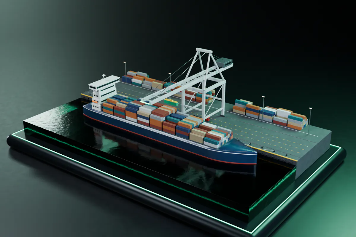 A gantry crane lifts an emerald container from a berthed container ship onto a miniature quay, with stacked containers and a waiting truck behind.